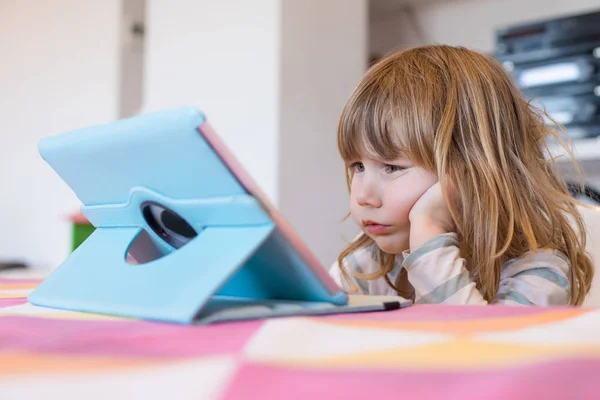 Ekelhafter Ausdruck eines kleinen Kindes, das digitales Tablet schaut — Stockfoto