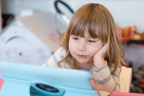 Frontansicht eines kleinen Kindes, das ein digitales Tablet betrachtet — Stockfoto