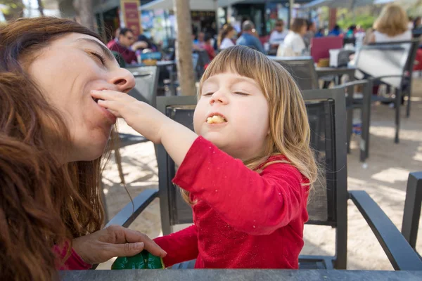 Criança e mãe comendo juntos sopro de queijo no café terraço — Fotografia de Stock