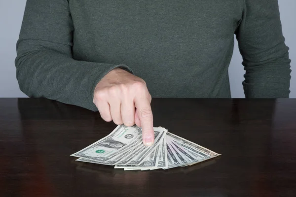 Man finger points a bundle of dollars — Stock Photo, Image
