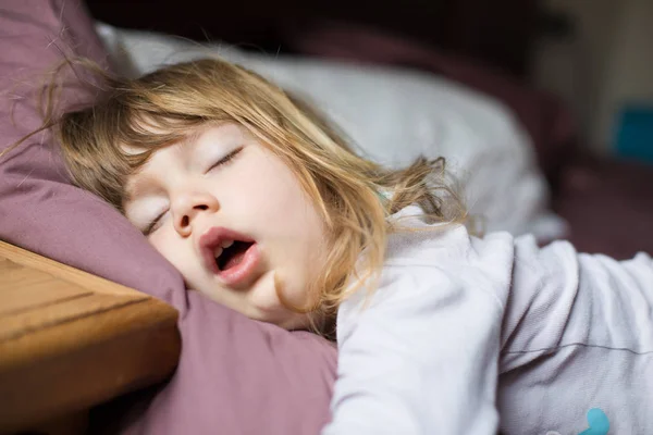Cara divertida de niño durmiendo en la cama king Fotos de stock libres de derechos