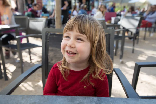 Retrato de uma criança sorridente sentada no café do terraço — Fotografia de Stock