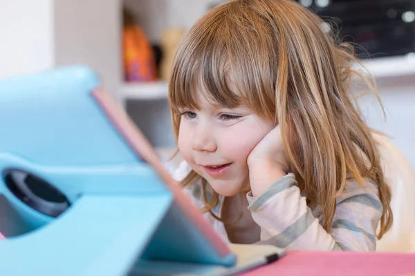 Lächelndes kleines Kind schaut digitales Tablet — Stockfoto