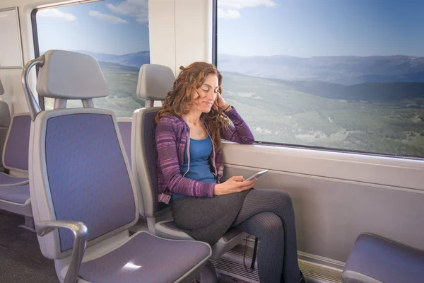 微笑的女士坐在火车使用移动 — 图库照片