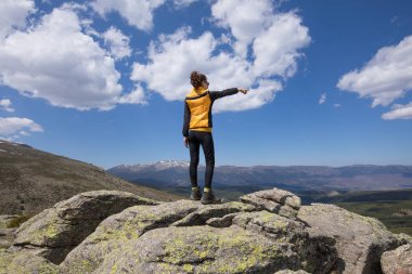 back woman on top of mountain pointing with hand clipart
