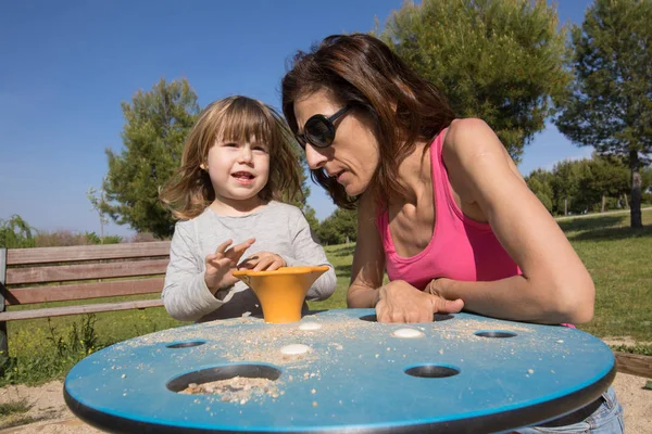 Criança e mãe brincando com areia no playground — Fotografia de Stock
