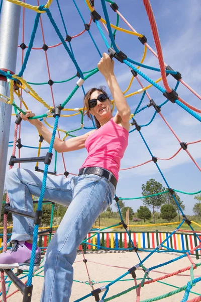 Woman climbing in rope ladder — Stock Photo, Image