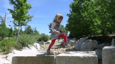 küçük kız taş bloklar üzerinde yürüyüş