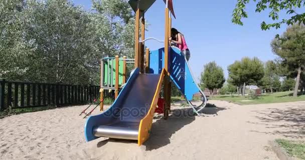 Dziecko i matka przesuwne o plac zabaw dla dzieci — Wideo stockowe