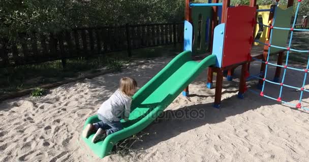 Child trying to climb slide from side — Stock Video