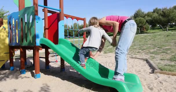 Mother teaching child to climb on slide — Stock Video