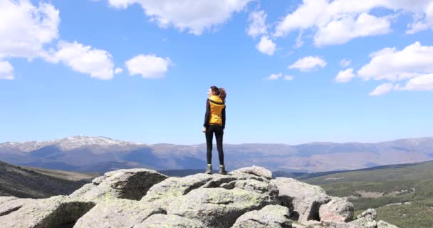 Woman on top of mountain watching valley — Stock Video