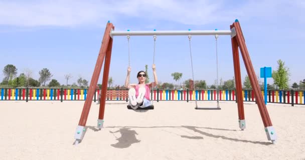 Mujer balanceándose en parque infantil — Vídeos de Stock