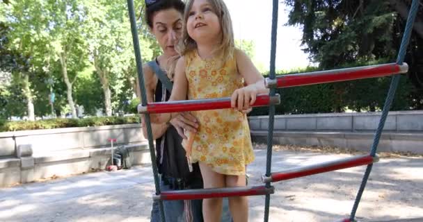 Niña y madre en escalera de patio de recreo — Vídeo de stock