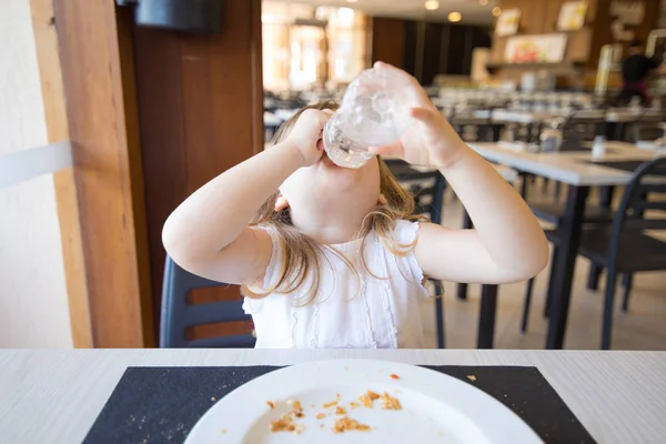 Klein kind drinken uit plastic fles in handen — Stockfoto