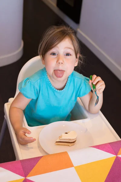 Criança comendo bolo saindo da língua — Fotografia de Stock