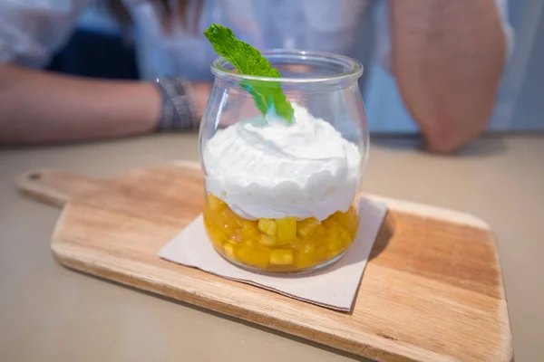 Yogurt con trozos de piña y hoja de menta en frasco de vidrio en woode — Foto de Stock