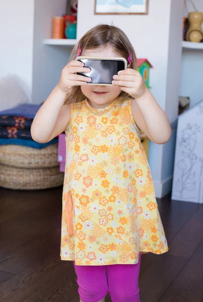Liten flicka visar blank skärm av mobiltelefon — Stockfoto