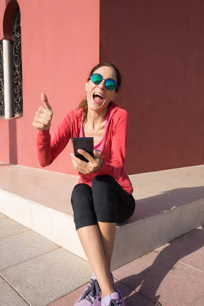 Vrouw schreeuwen met telefoon en duim omhoog teken — Stockfoto