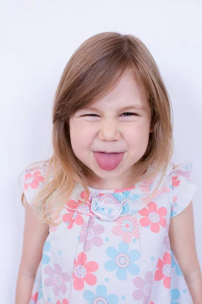 Szőke kislány, ki nyelvét ragadt vicces portréja Jogdíjmentes Stock Képek