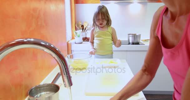 Μικρό παιδί με μητέρα προετοιμασία πατάτες — Αρχείο Βίντεο