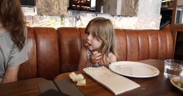 Little child eating croquette in restaurant — Stock Video