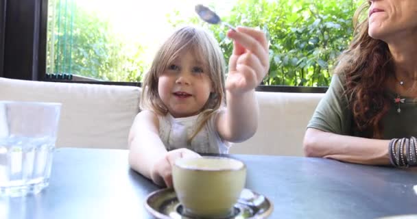Little child playing moving sugar with her mother in restaurant — Stock Video