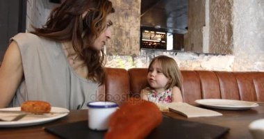 küçük çocuk annesi restoranda konuşuyor