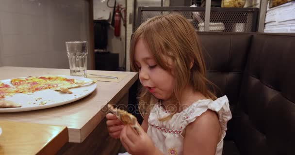 Little girl in restaurant devouring pizza — Stock Video