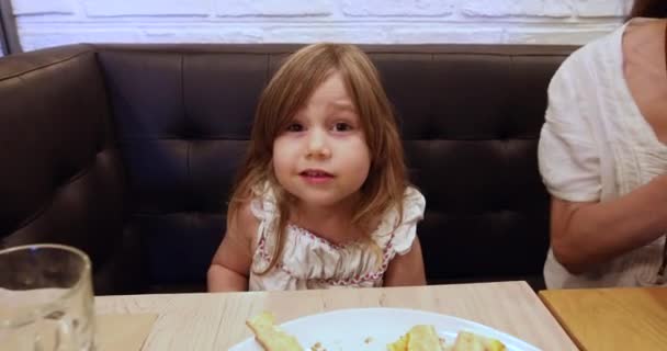 Маленька дівчинка в ресторані говорить — стокове відео