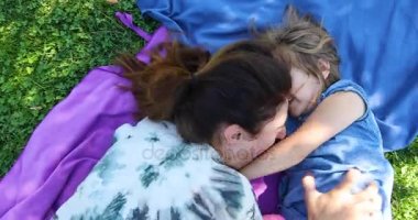 Anne çimlere yatan kızı gıdıklıyor