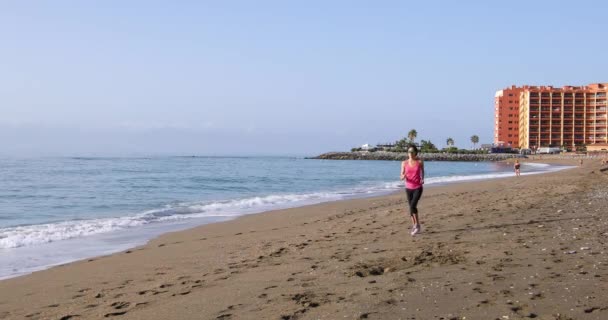 Mujer deportiva corriendo en la playa — Vídeos de Stock