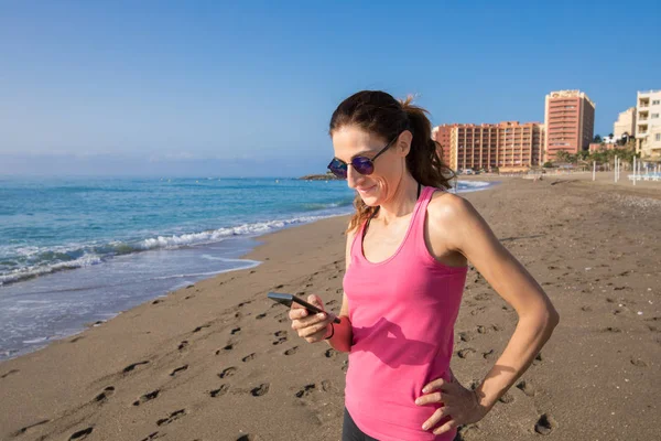 Γυναίκα που χρησιμοποιούν κινητό τηλέφωνο στην παραλία για: Τορεμολίνος — Φωτογραφία Αρχείου