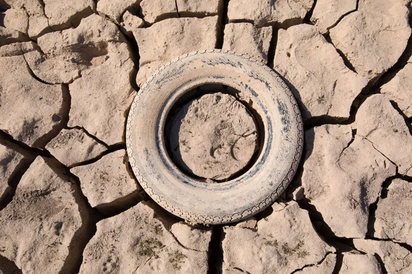 废弃轮胎埋在干燥的土地 — 图库照片