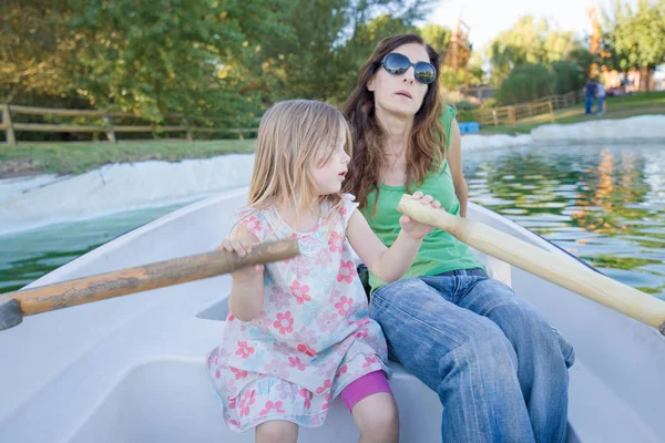 Menina remando em um barco ao lado da mulher — Fotografia de Stock