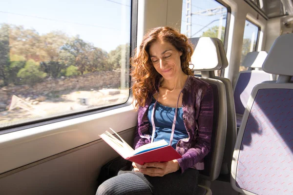 Felice donna in treno lettura libro — Foto Stock