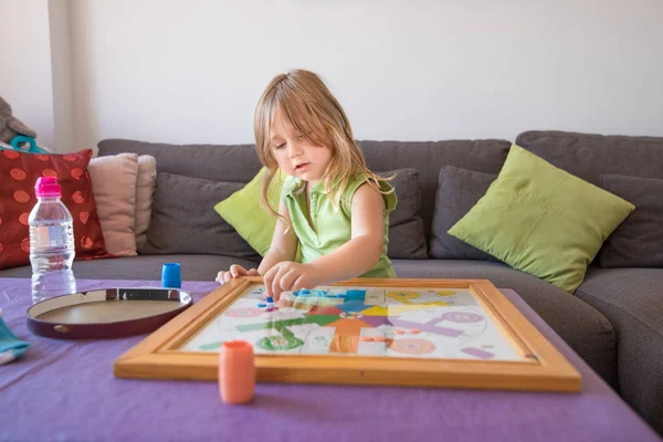Little child playing parchis game at home in summer — Stock Photo, Image