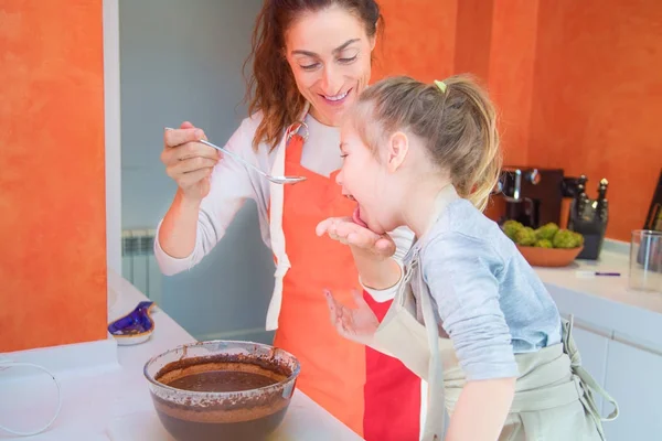 Lustige Mutter und Mädchen, die geschlagene Schokoladencreme probieren — Stockfoto