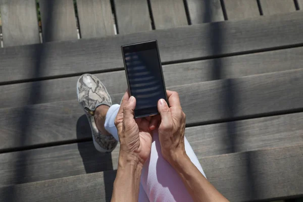 Visão horizontal superior das mãos da mulher digitando no telefone móvel em branco — Fotografia de Stock