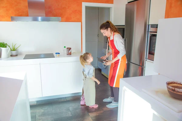 Madre y niña en la cocina tomando un molde para cocinar una ca — Foto de Stock