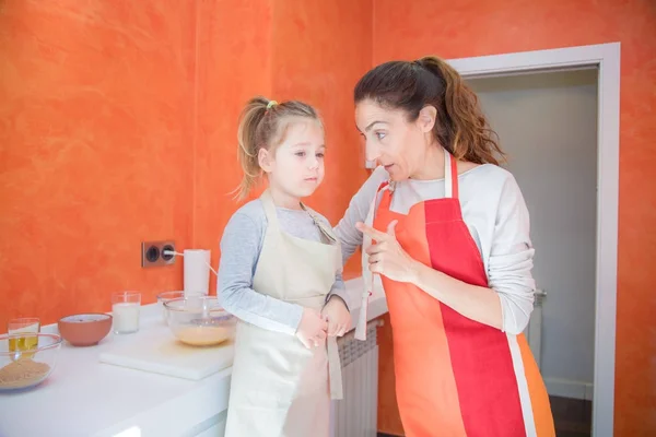 Madre hablando con la niña cocinando juntos en la cocina — Foto de Stock