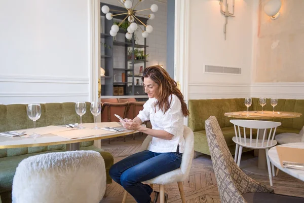 Restoranda hareket eden smartphone kullanan meşgul kadın — Stok fotoğraf