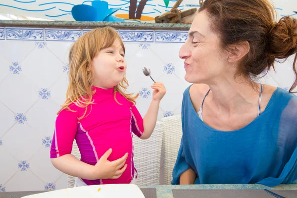 Criança e mãe comendo paella e sorrindo — Fotografia de Stock