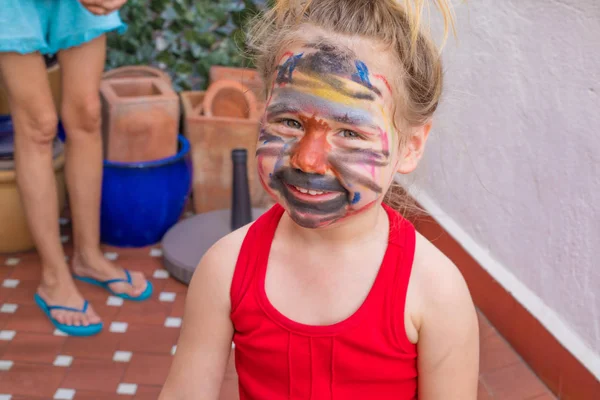 Malovaný obličej holčička se dívá — Stock fotografie