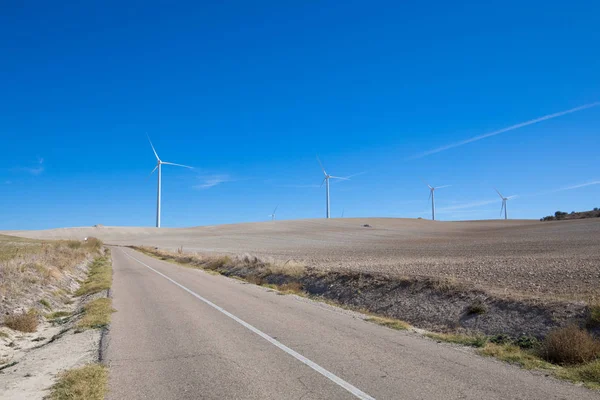 Carretera rural junto a turbinas eólicas — Foto de Stock