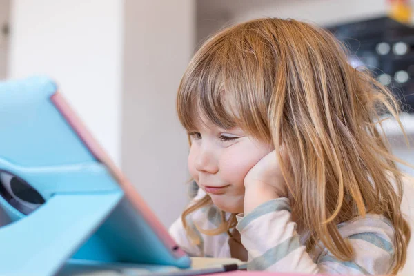 Lustiger Ausdruck eines kleinen Kindes, das ein digitales Tablet betrachtet — Stockfoto