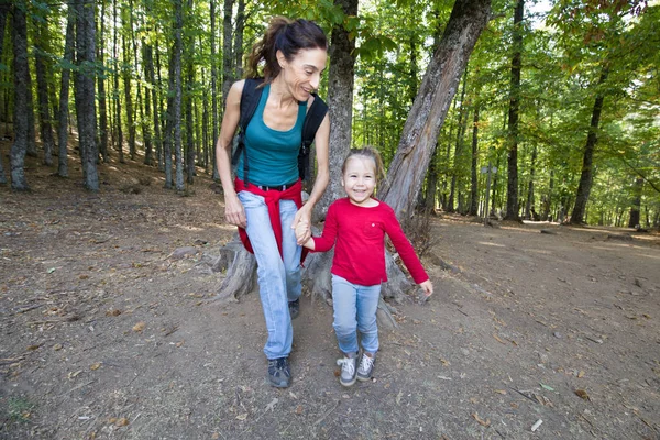 Matka a dítě směje v lese kaštanů — Stock fotografie