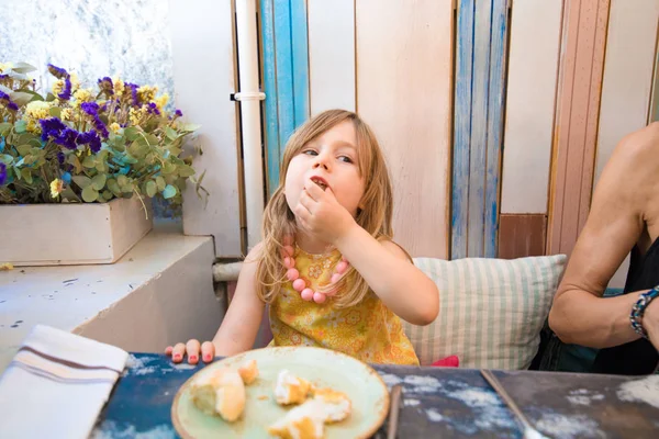 Menina comendo pão com a mão no restaurante — Fotografia de Stock