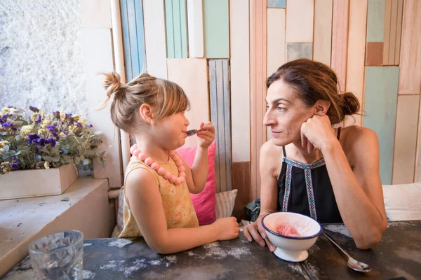 Menina comendo sorvete com a mãe no restaurante — Fotografia de Stock