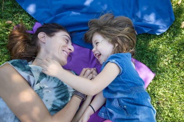 Küçük kız ve annesi parkta yalan gülüyor — Stok fotoğraf